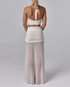 Back view of Elara ivory halter crop top with tie neck detail styled with the Elara sheer maxi skirt in studio.