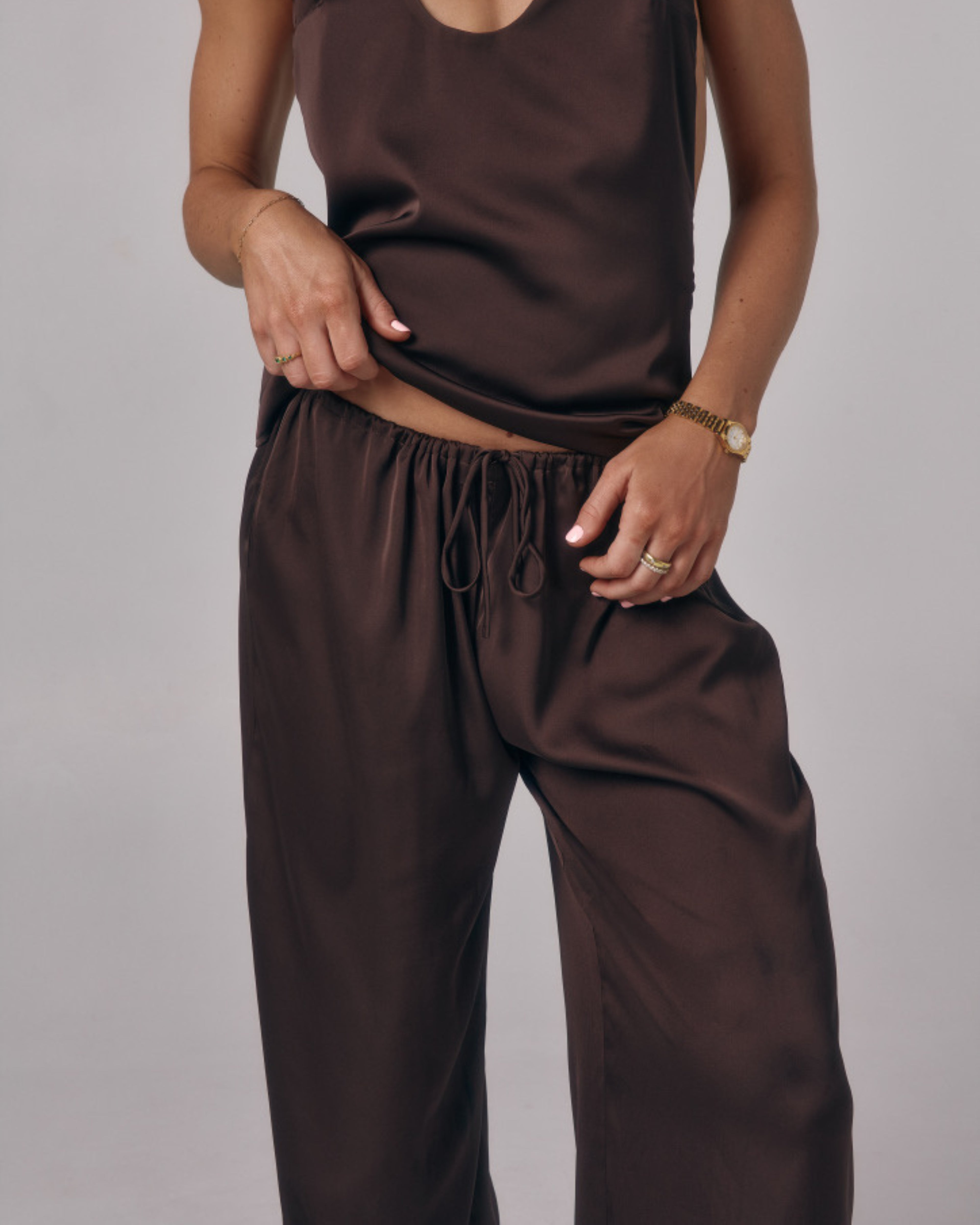 Close-up of Paloma chocolate brown satin lounge pants showing elastic drawstring waist and smooth satin fabric.