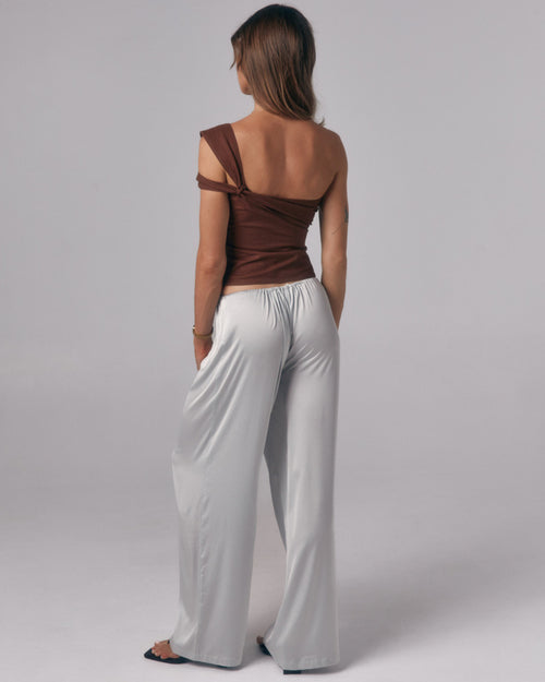 Back view of Paloma light blue satin lounge pants with wide leg fit in a studio setting.