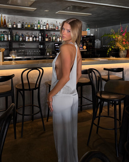 Back view of model wearing the powder blue Paloma Set with open-back satin top and matching maxi skirt.