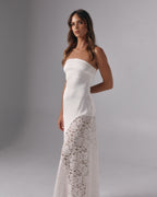 Model wearing Soleil ivory strapless maxi dress with lace skirt panel in a studio setting
